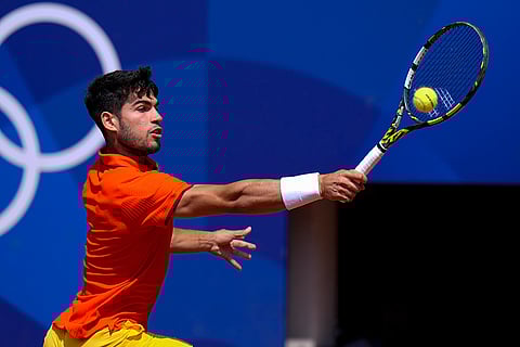 Carlos Alcaraz returns a shot to Felix Auger-Aliassime